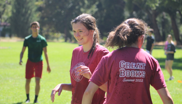 Water-spattered prefects pass one another on the field
