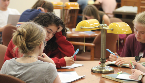 Students take notes around a table