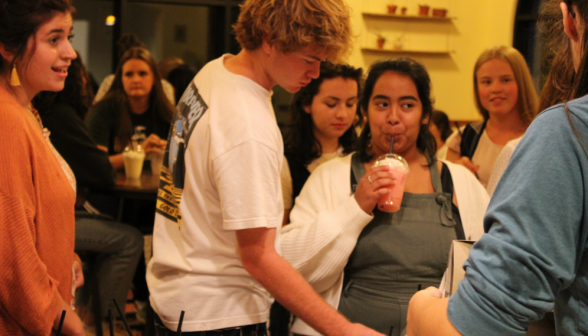 A small group of students gather around a table