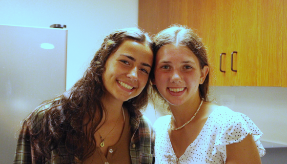 Two pose for a photo in the dorm kitchen