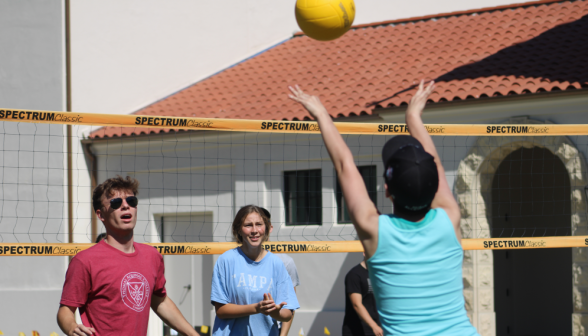 A student send the volleyball over the net