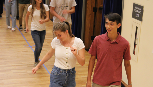 Students pairs step around the room