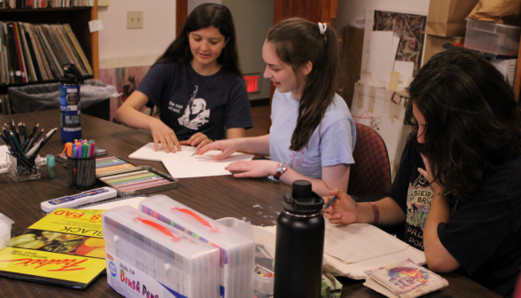 Three students draw together