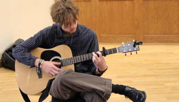 Closeup: another student auditions with a guitar