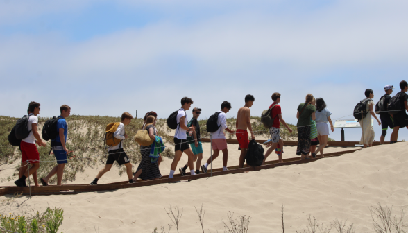 Students trek over the rise to the beach