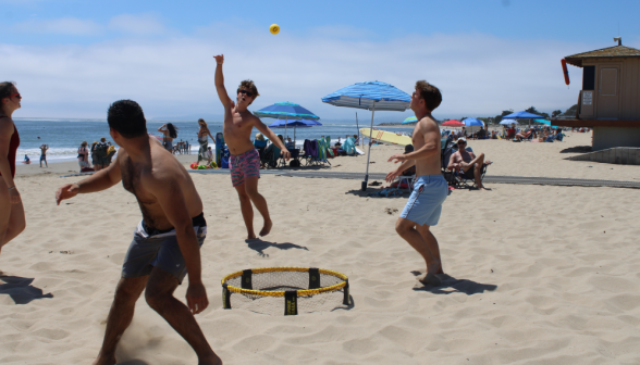 A game of Spikeball on the beach