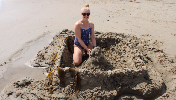 A student inside an impressive sandcastle