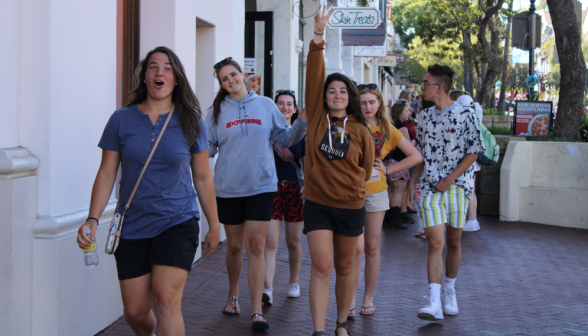 Meg Murphy makes the "peace" sign, leading the procession of summer programmers down a street