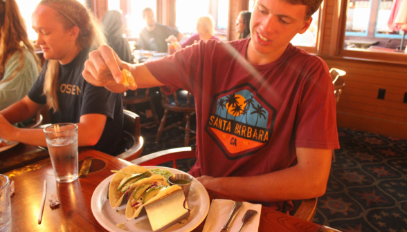 A student squeezes a lemon slice onto his tacos