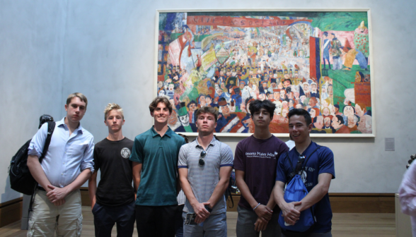 Six students pose afront a painting