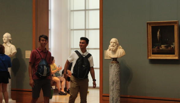 Two students in a doorway between two busts