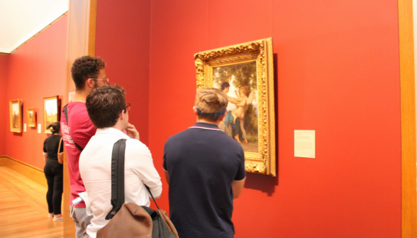 Three students admire a painting