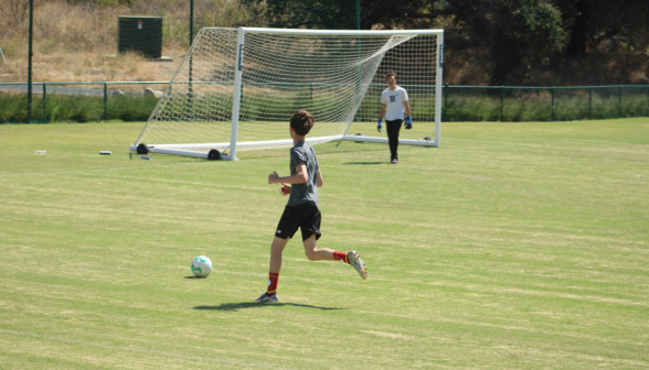 Two playing soccer on the athletic field