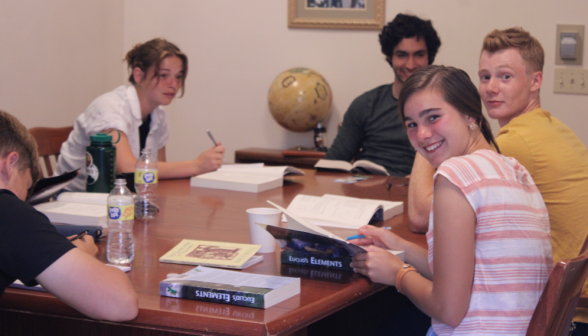 Students study Euclid around a table