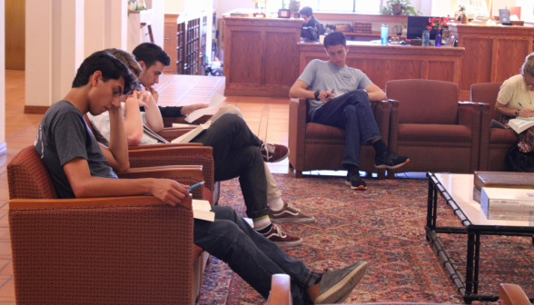 Students study in the library armchairs