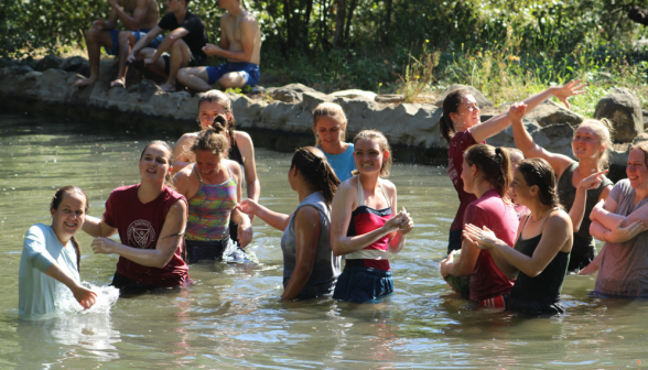 Students laugh and chat in the pond