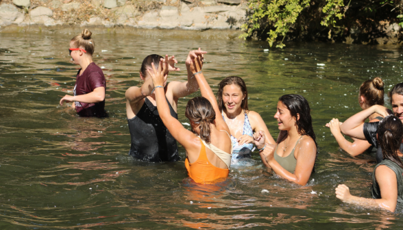 Students high-five in the pond