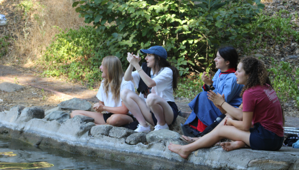 Students relax and chat on the bank