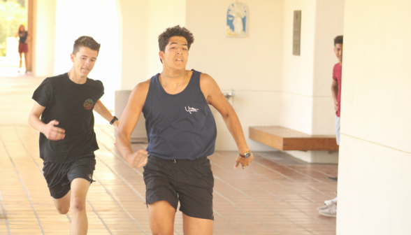 Two students sprint down the arcade