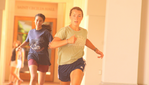 Two students run past St. Cecilia's