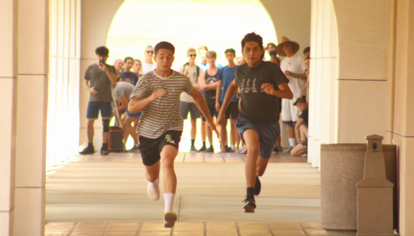 Two sprint before a crowd of onlookers