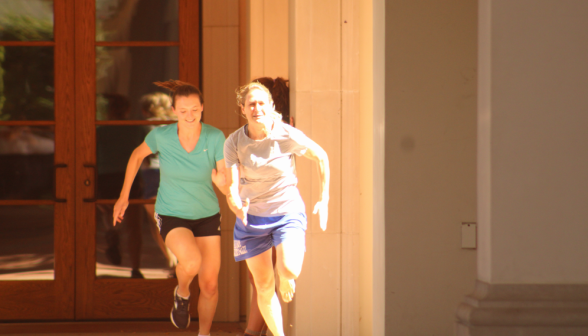 Two students run by the doors of St. Cecilia's