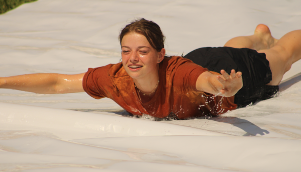 A student speeds down the slide