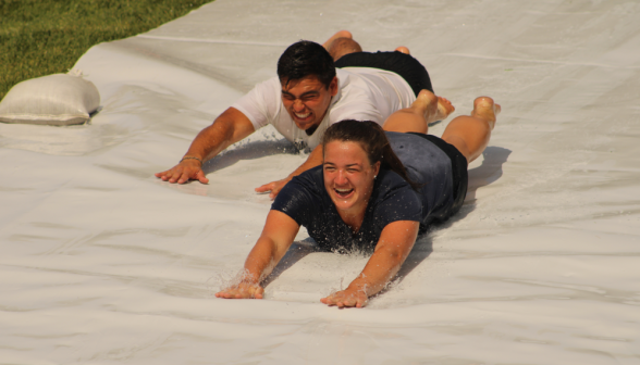 Another two go down the slide in the "Superman" pose