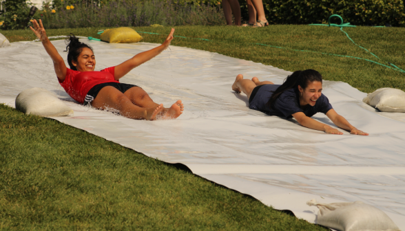 Two students go down the slide