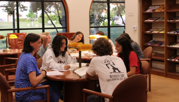 Four study at one of the tables in the library's left wing