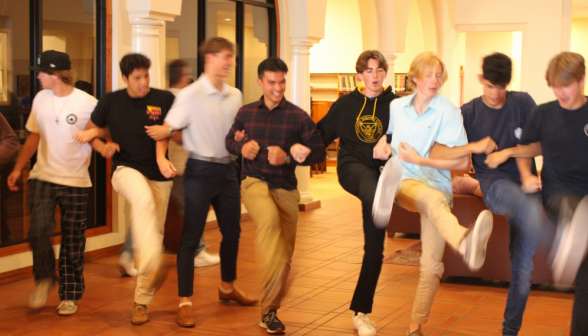 Arms locked, eight students engage in a peculiar dance on the library floor