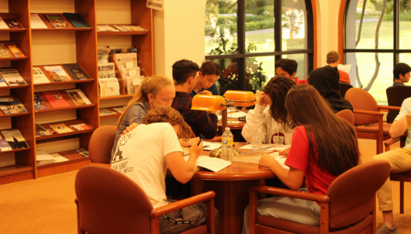 Students study at tables in the library