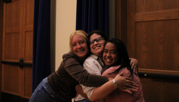 Three girls hug and smile for the camera