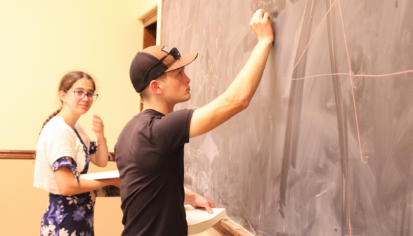 Two students practice their props at the board