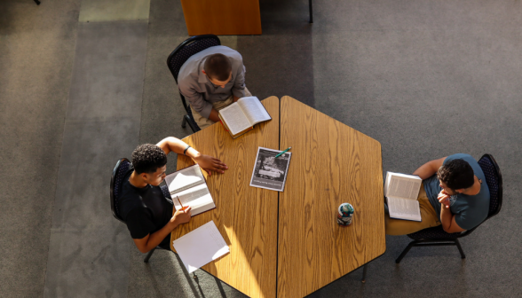 Overhead: three study at a hexagonal table
