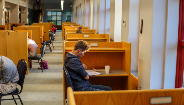 View down a long row of students studying at individual desks