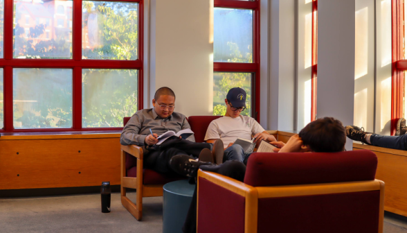 Four studying in the music room, with blazing colors out the window