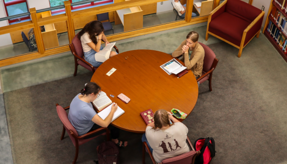 Four study at a middle-floor circular table