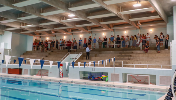 Jon Daly addresses the students in the benches by the pool