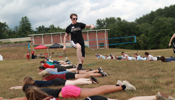 A student runs, carefully stepping over his fellow students who are lying in a row