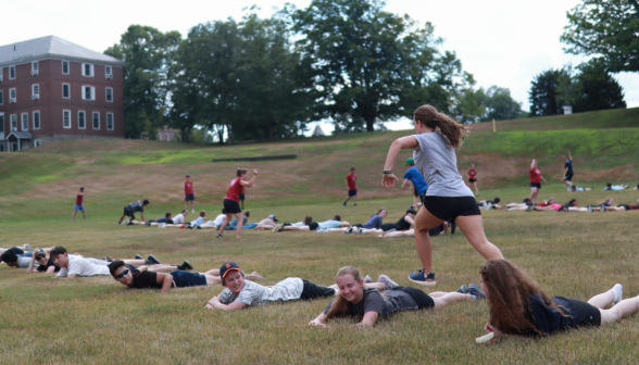 Another student leaps over her teammates