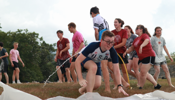 A student jumps onto the slide