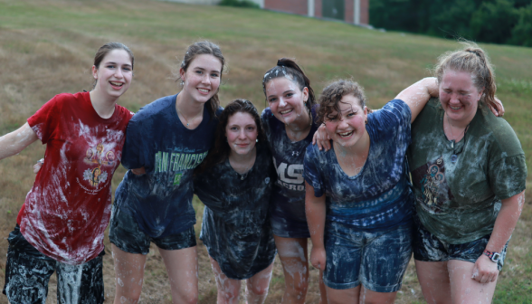 Six pose together, covered in suds