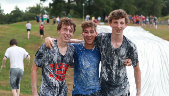 Three pose for a picture, covered in suds