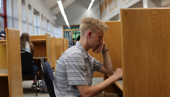 A student studies at an individual desk