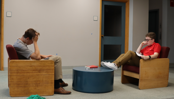 Two study in armchairs across from one another