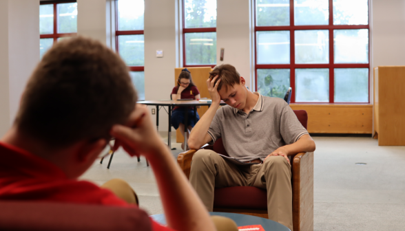 Over-the-shoulder shot: two studying in armchairs across from each other