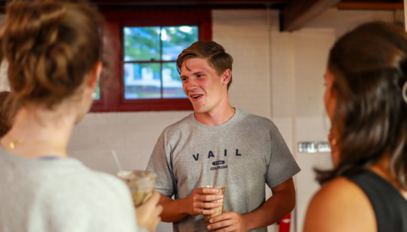 A prefect chats with students over drinks