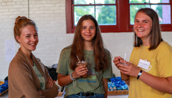 Three pose with their drinks