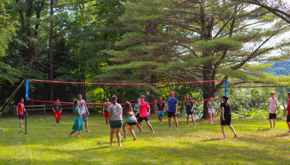 Programmers play volleyball on the grass court